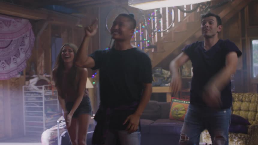 Three friends standing in the living room cheering and clapping