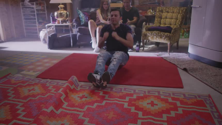A young mance dances while his friends film him on a smartphone