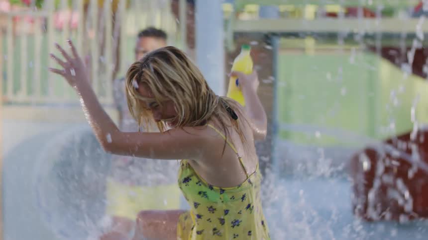 Young friends splash each other with water in a pool