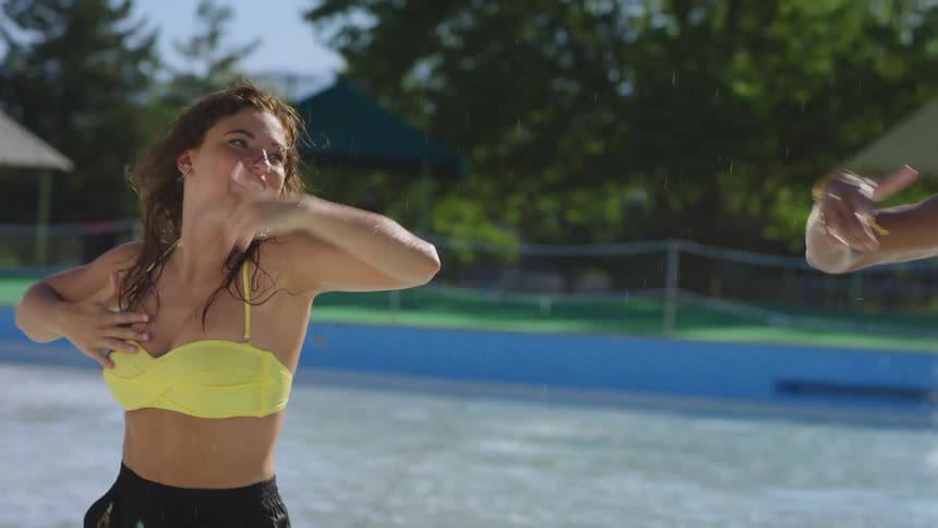 Three friends dance in the pool at a water park