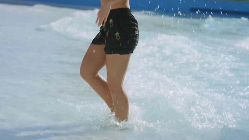 A teenage girl dances in the water at a waterpark