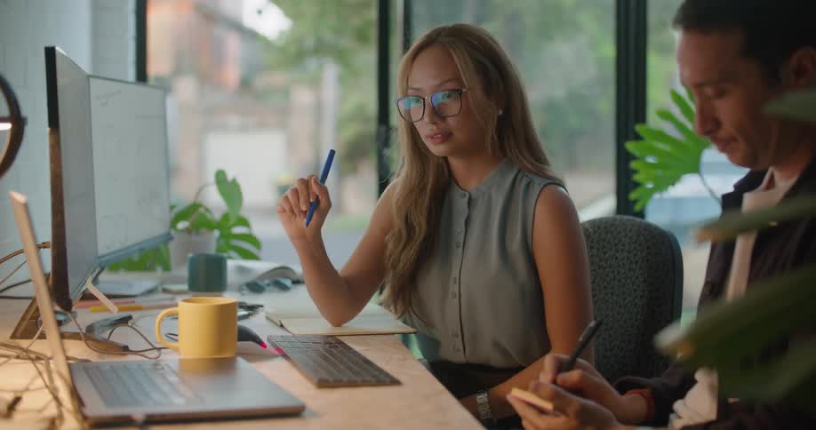 A woman and man are collaborating at a desk