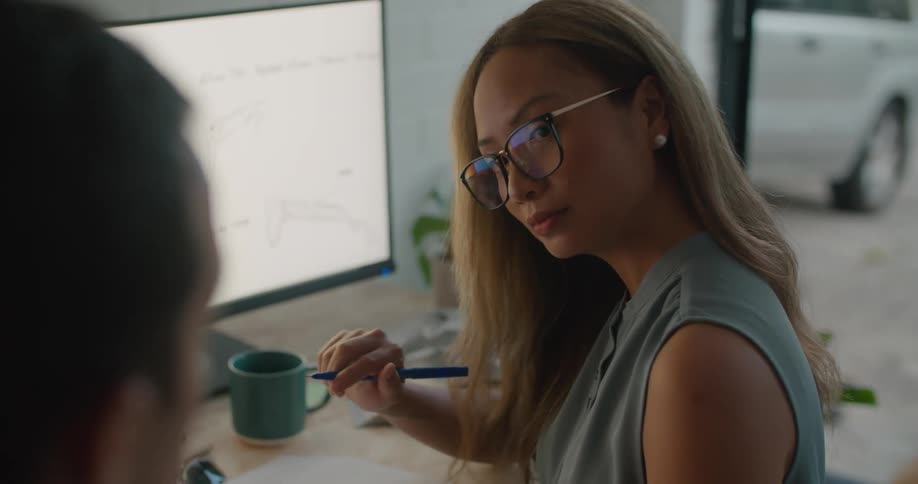 Man and woman sit in office discussing designs related to shades
