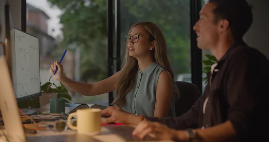 Coworkers talk and look at designs on the screen