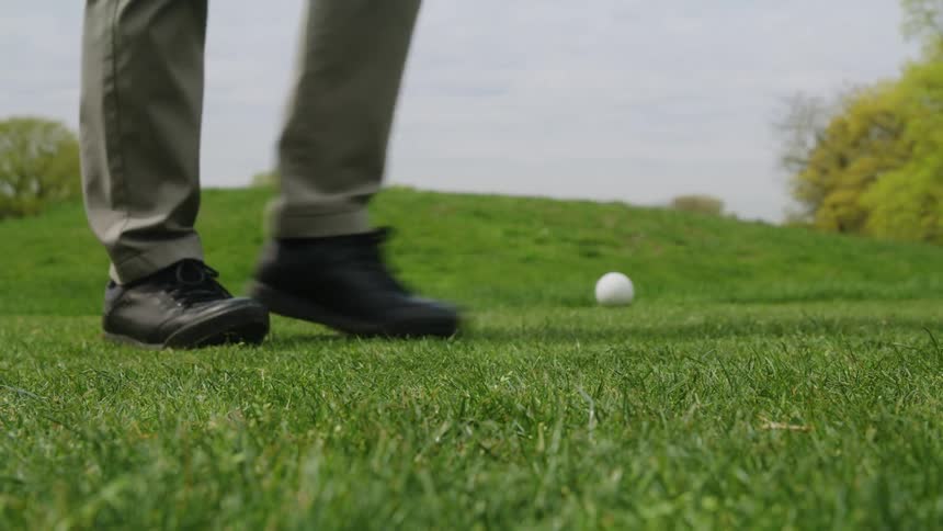 A person drives the golf ball