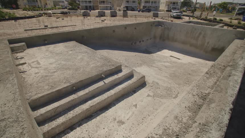 Cement is poured and shaped for a buildings foundation and pool