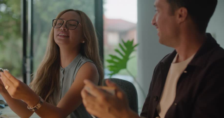Two coworkers talk and laugh in the office