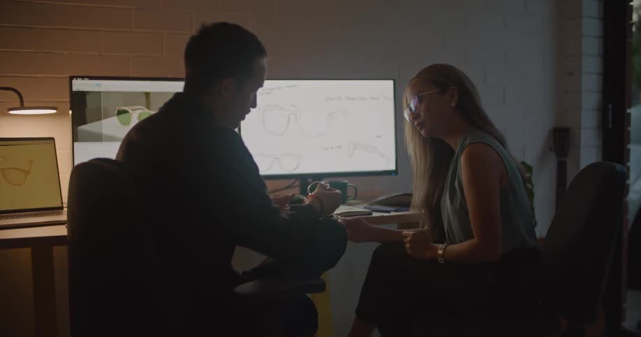 Two people working on glasses together in an office