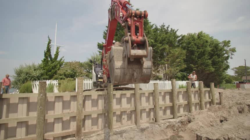 A man operating a bulldozer picks up dirt at a construction site