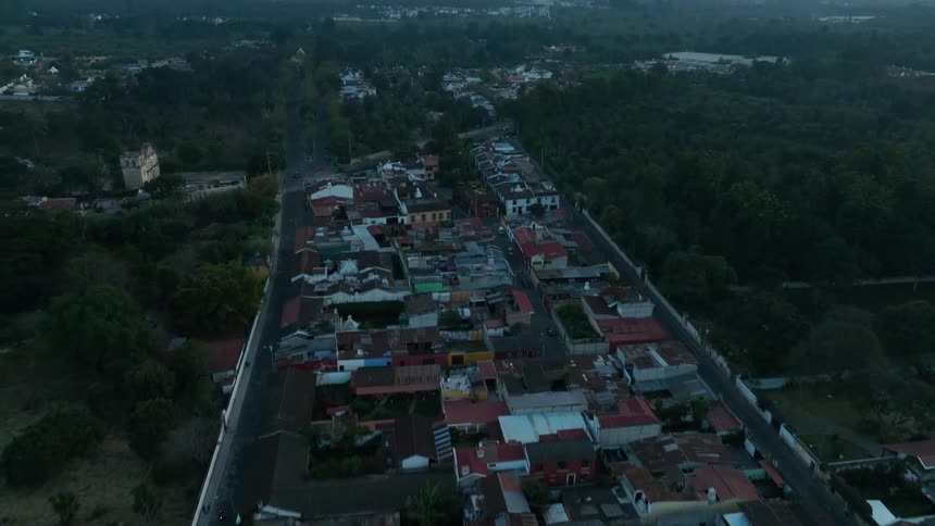 Homes in a neighborhood sit near the trees at the base of a mountain