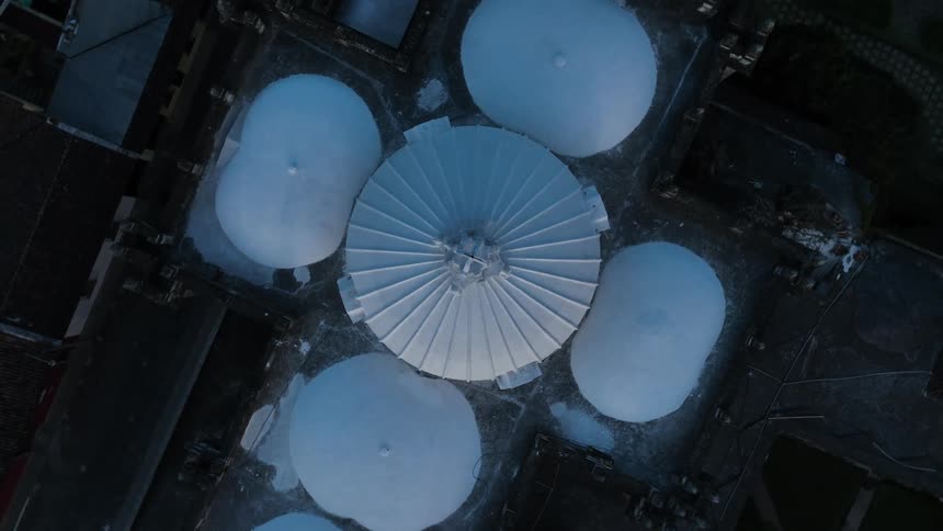 An aerial view of a city with snow on the roof of a building