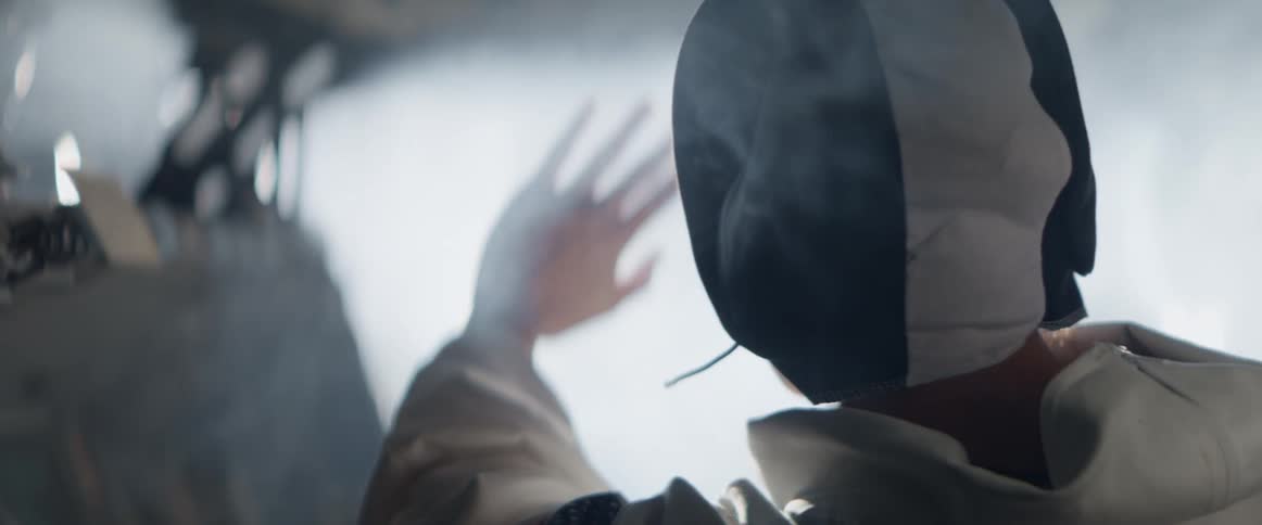 The astronaut reaches into the smoke in the cockpit