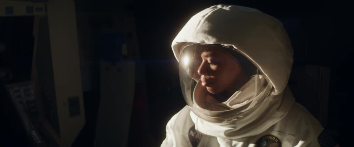 Woman in a spacesuit adjusts the controls on a console