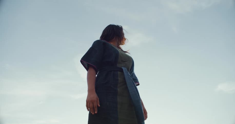 Hispanic woman standing outdoors looking around confused during day time
