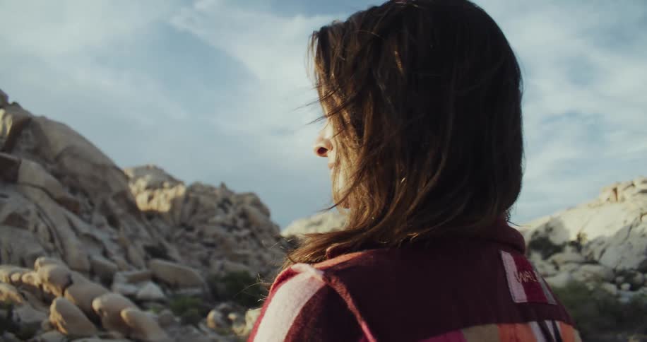 A woman is looking around at the hills