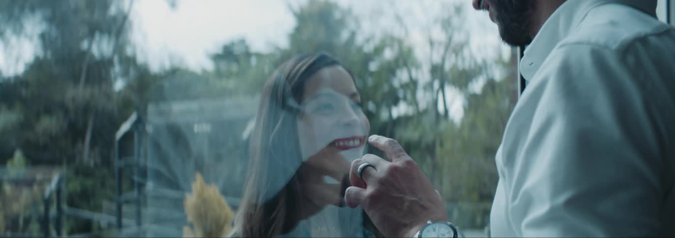Man and woman romantically looking at each other and interacting through a glass window