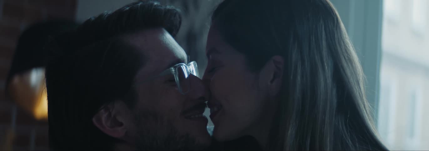 Man and woman kissing and smiling on the living room