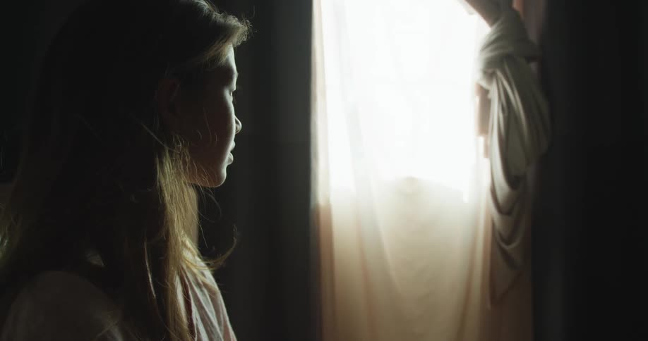 A woman is watching the world through a window