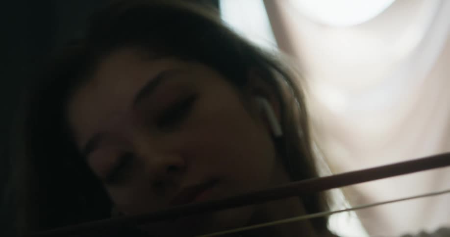 Woman plays string instrument with her eyes closed