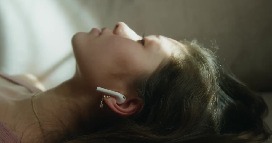 A woman is listening to music while laying down