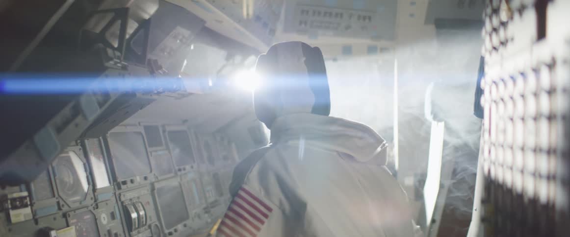 The astronaut is looking out the window in the cockpit