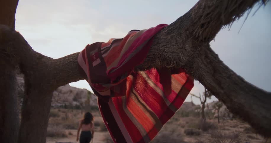 A woman runs and jumps around in the desert