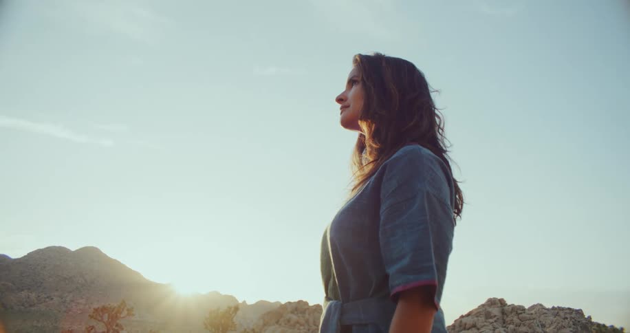Hispanic woman standing outdoors in the nature at a sunny day