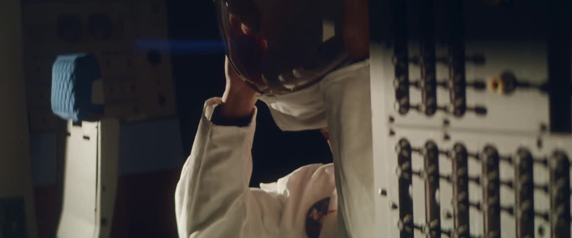 A female astronaut removes her space suit helmet