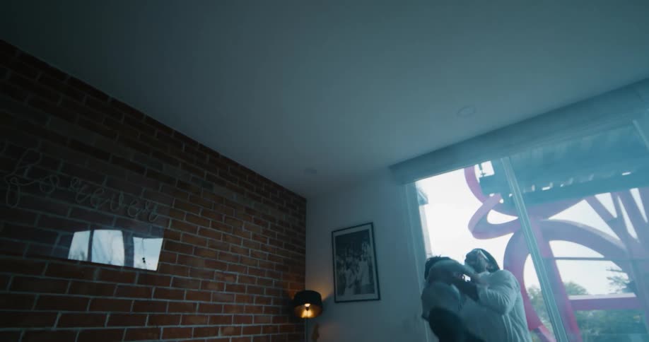 Father playing with his son picking him up from the ground and throwing him up in the air at the living room