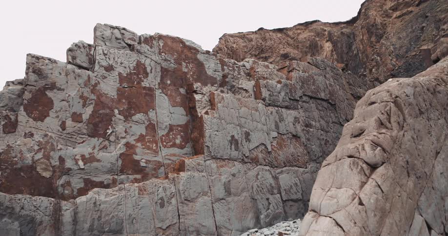 Multiple cracks are visible in a rocky mountainous formation that contains several sheer surfaces