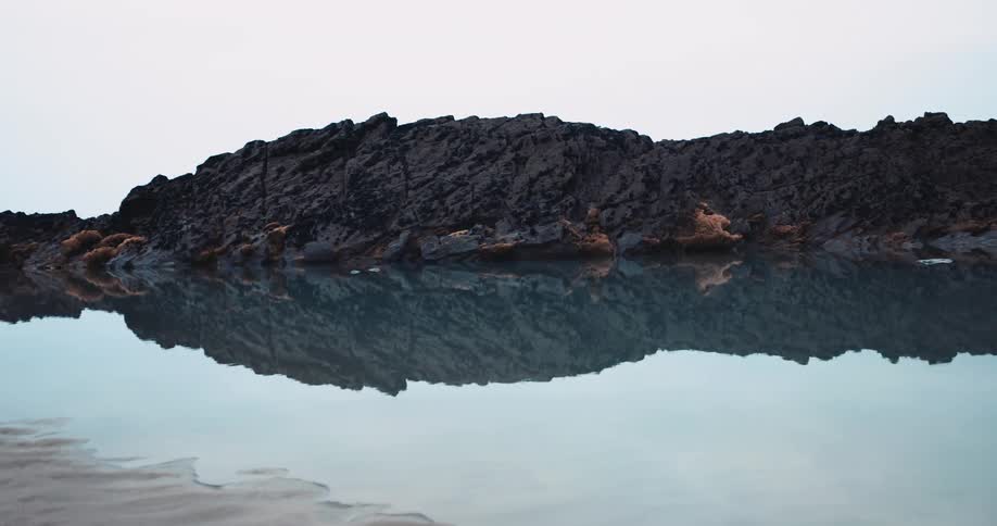 The shore is surrounded by calm water
