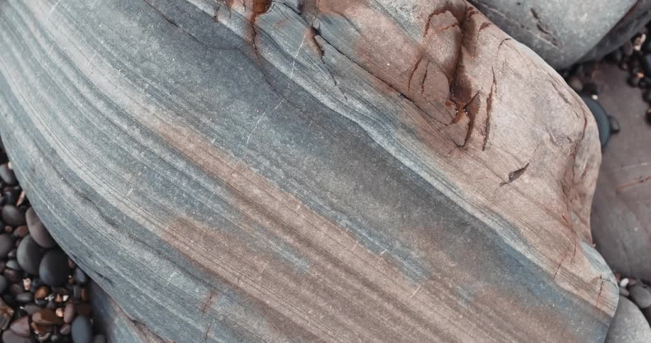 Small rocks and large boulders surround a mesa in a canyon