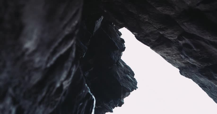 The crevice shows a cloudy sky above