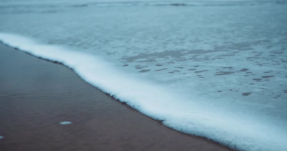 Small tides slowly reaching the beach at the coast