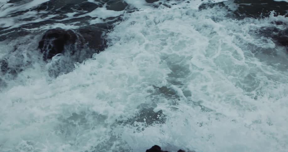 Ocean waves crash against oceanside cliff
