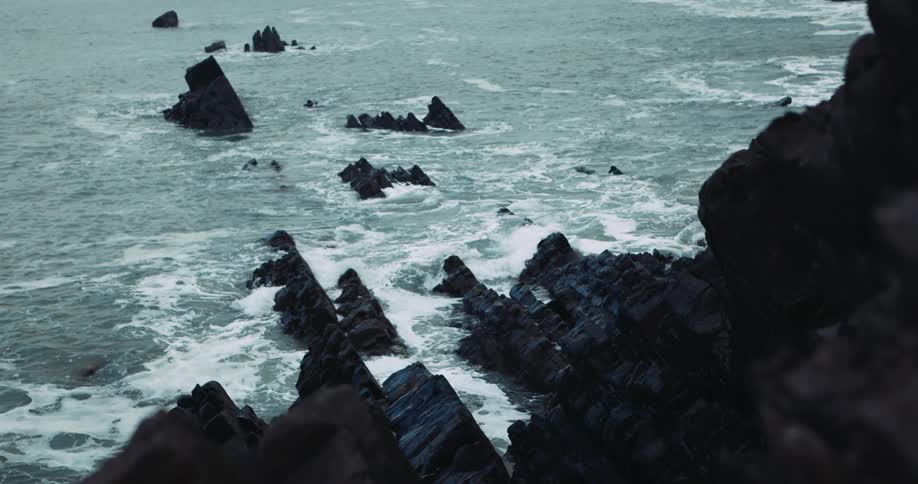 Waves crash onto rocks along the coast