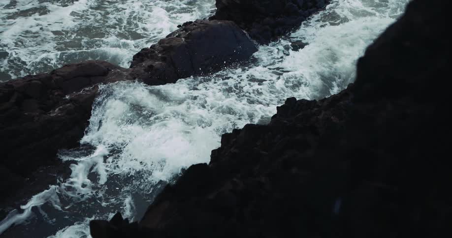 Ocean waves crash against oceanside cliff