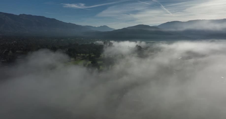 Dense clouds move over a neighborhood near a mountain range