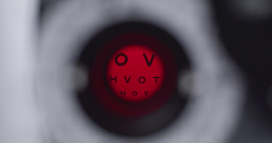 Lenses are flipped to determine prescription as eye chart shows through viewing aperture