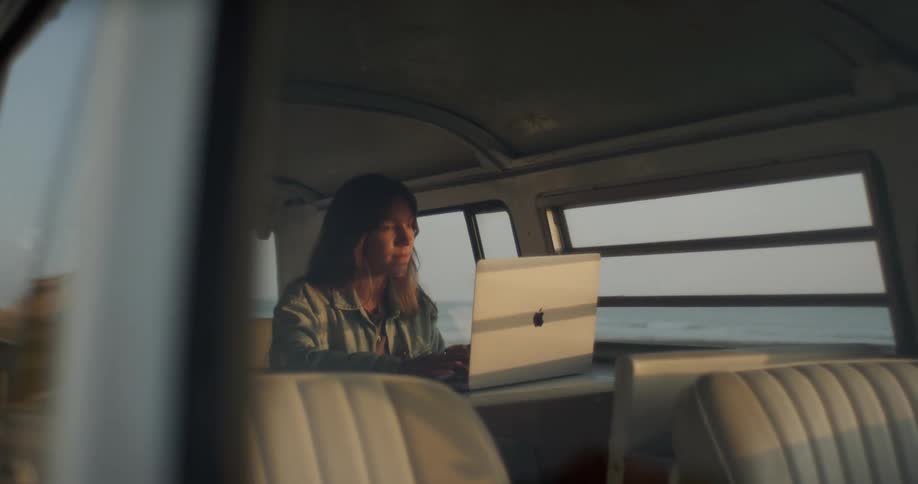 A woman is typing on a laptop while in a boat