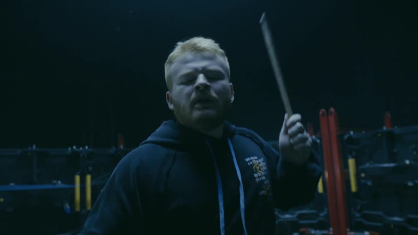 Redheaded drummer wearing a hoodie plays the drums