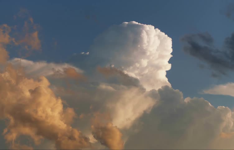 Different colored clouds floating against a blue sky