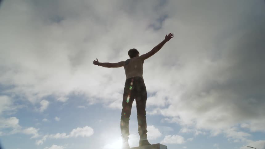 A man raises his arms to the sky