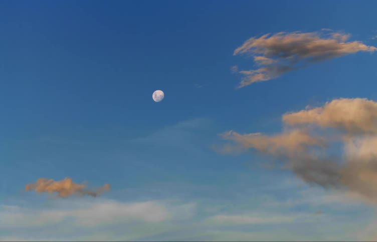 A view of the moon next to clouds