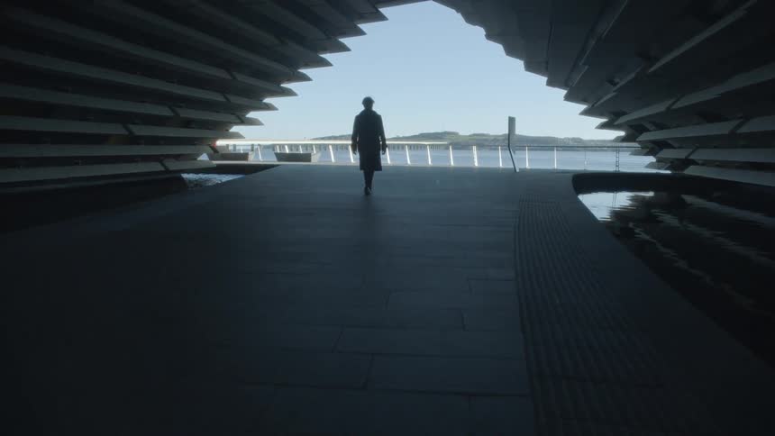 A man walking outdoors near water