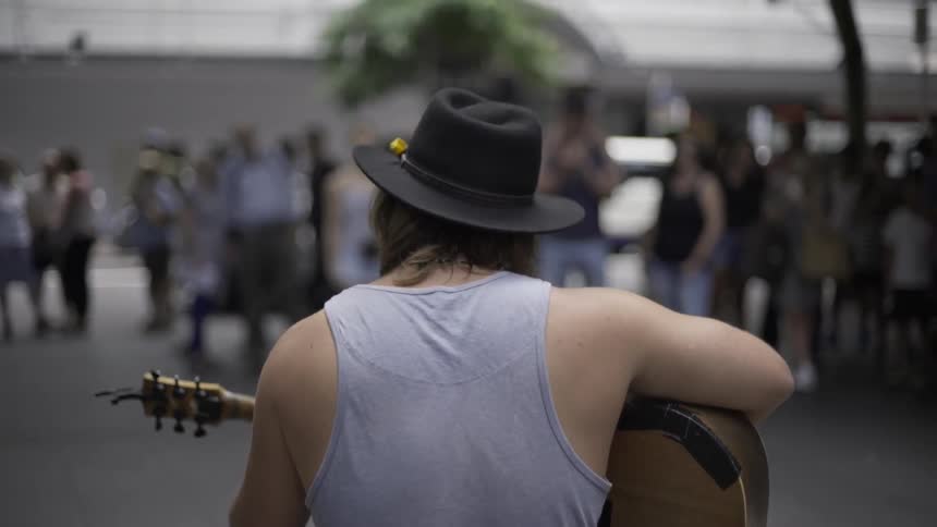 A man is playing an instrument on the street
