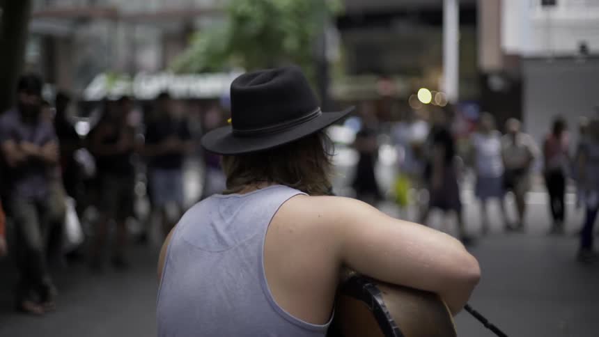 A man plays guitar in front of a crowd of people