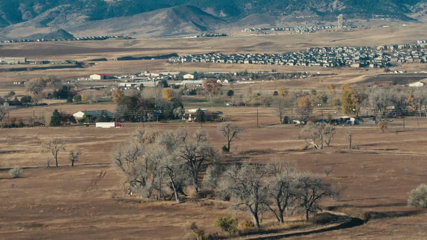 A shipping truck drives next to a flat grassland