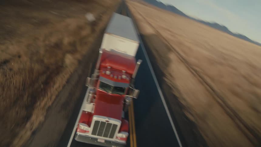 A semi truck drives down a rural two lane highway