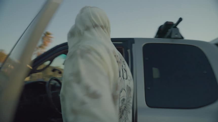 A man opens the driver side door of his truck and gets in with a female in the passenger seat